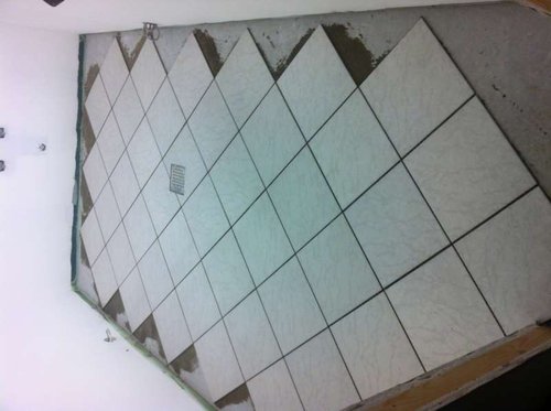 Så blir der lagt fliser. Læg lige mærke til den lækre udskæring omkring afløb. :-)